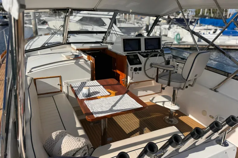 Slide: The Image of 1999 Grand Banks 38 Eastbay EX yacht interior with helm, seating, and table setup. - 13