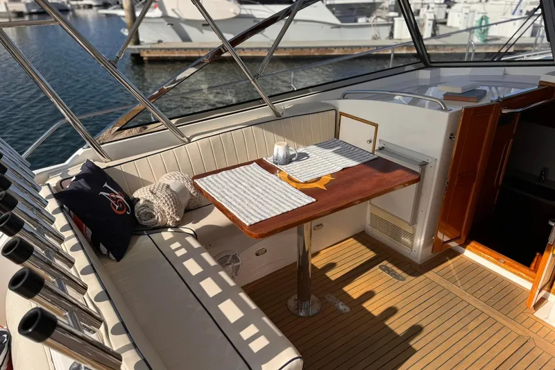 Slide: The Image of Cozy seating area on 1999 Grand Banks 38 Eastbay EX yacht with table and cushions. - 2