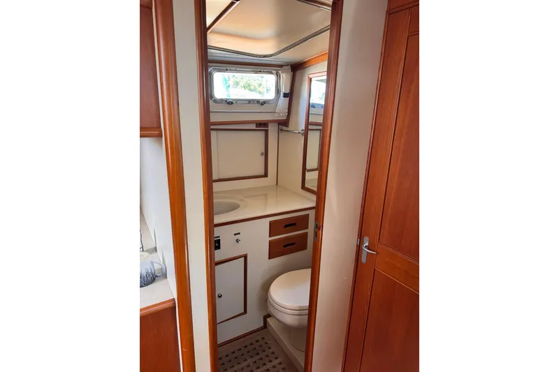 Slide: The Image of 1999 Grand Banks 38 Eastbay EX yacht bathroom with wooden cabinetry and porthole window. - 25