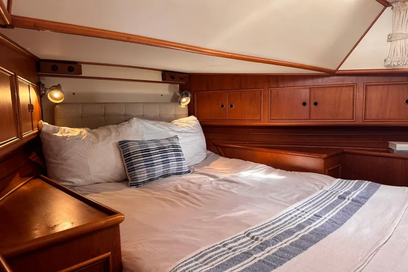 Slide: The Image of Cozy cabin interior of 1999 Grand Banks 38 Eastbay EX with wood paneling and comfortable bedding. - 28