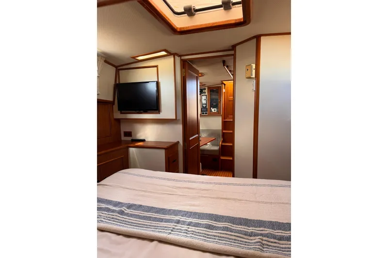 Slide: The Image of Interior of 1999 Grand Banks 38 Eastbay EX yacht, featuring cozy cabin with TV and wood accents. - 29