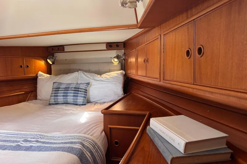 Slide: The Image of Cozy cabin interior of 1999 Grand Banks 38 Eastbay EX with wooden cabinetry and comfortable bedding. - 4