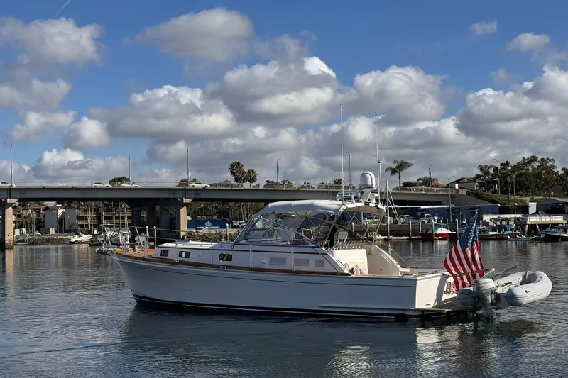 Slide: The Image of 1999 Grand Banks 38 Eastbay EX yacht docked in a marina under a cloudy sky. - 7