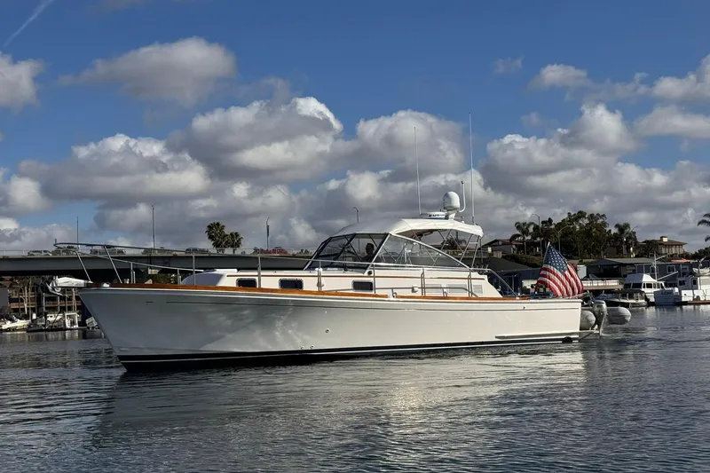 Slide: The Image of 1999 Grand Banks 38 Eastbay EX yacht on calm water under a cloudy sky. - 8