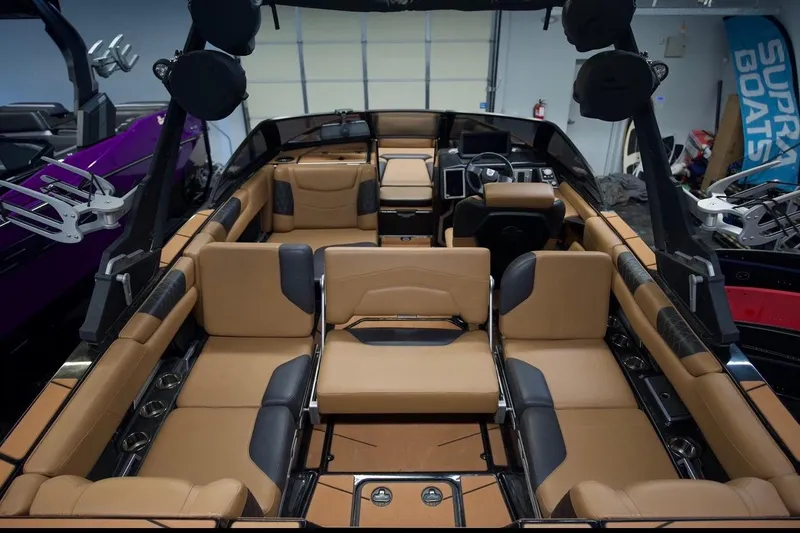 Slide: The Image of 2021 Malibu M220 boat interior with tan and black seating, showcasing luxury design. - 11