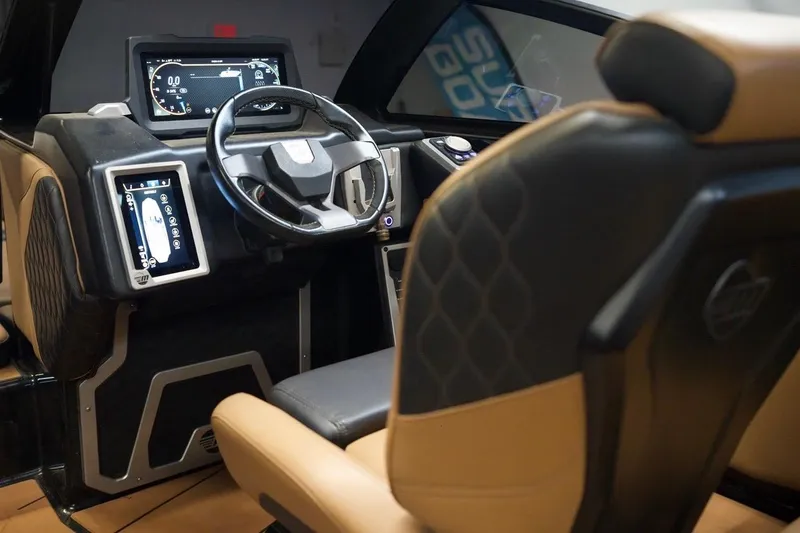 Slide: The Image of Interior of a 2021 Malibu M220 boat featuring modern dashboard and steering wheel. - 14