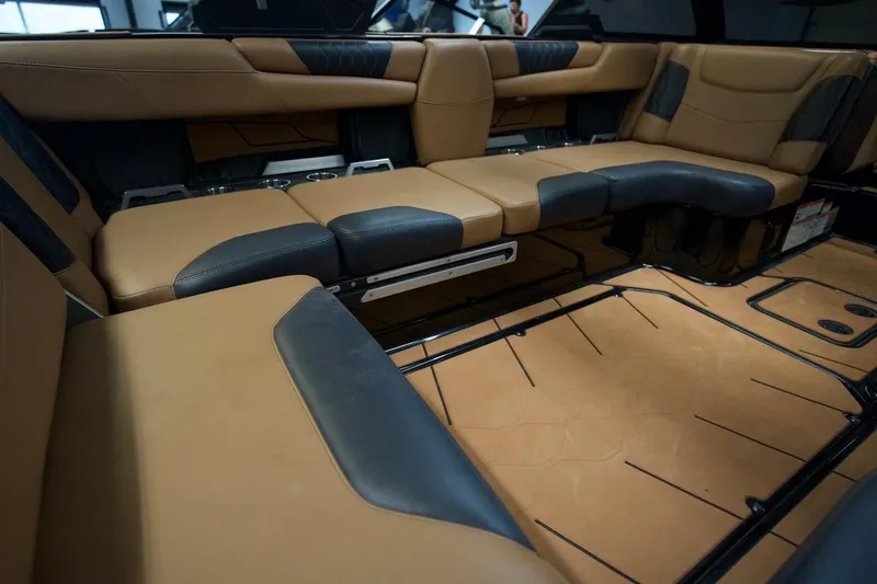 Slide: The Image of Luxurious interior of a 2021 Malibu M220 boat with tan and black seating. - 16