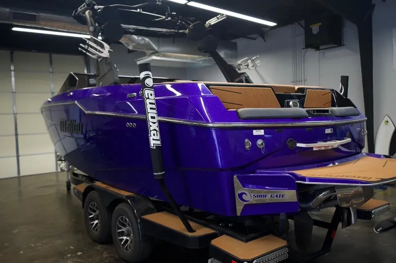 Slide: The Image of 2021 Malibu M220 boat in a garage, featuring a vibrant purple exterior. - 3