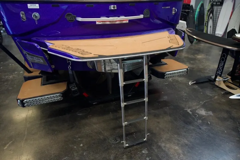 Slide: The Image of 2021 Malibu M220 boat rear view with swim platform and ladder in showroom. - 4