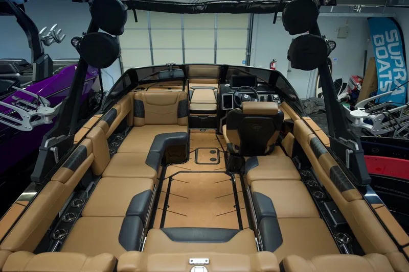 Slide: The Image of 2021 Malibu M220 boat interior with luxurious tan seating and modern dashboard. - 7