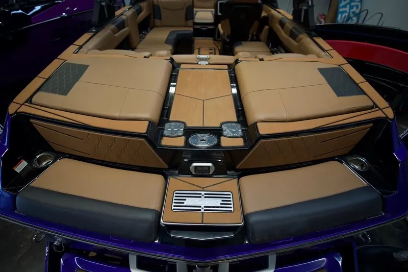Slide: The Image of 2021 Malibu M220 boat interior with tan leather seating and modern design elements. - 8