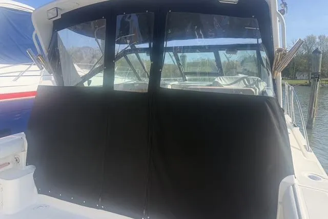 Slide: The Image of 2001 Tiara Yachts 2900 Open with black canvas cover, docked by the water. - 10