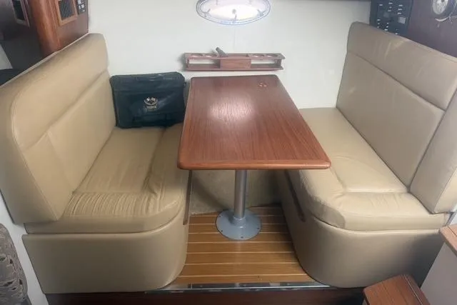 Slide: The Image of Interior of 2001 Tiara Yachts 2900 Open with beige seating and wooden table. - 35