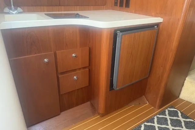 Slide: The Image of 2001 Tiara Yachts 2900 Open interior with wooden cabinetry and compact fridge. - 42