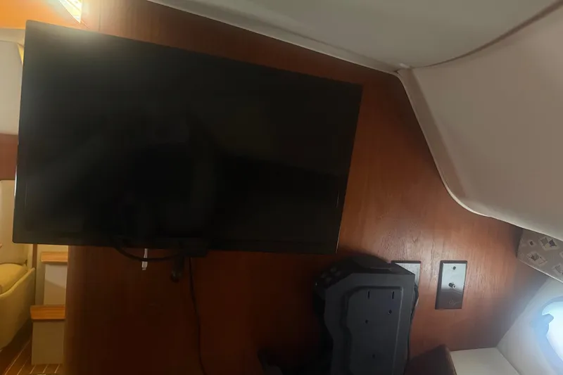 Slide: The Image of Interior of 2001 Tiara Yachts 2900 Open with mounted TV and wooden paneling. - 47