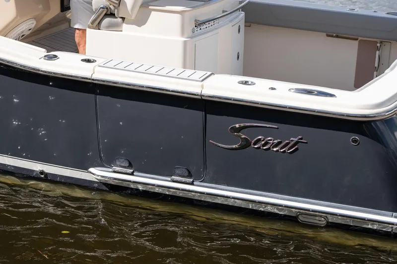 Slide: The Image of 2019 Scout 320 LXF boat, sleek design, docked on water. - 10