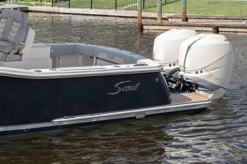 Slide: The Image of 2019 Scout 320 LXF boat with dual engines docked on water. - 11