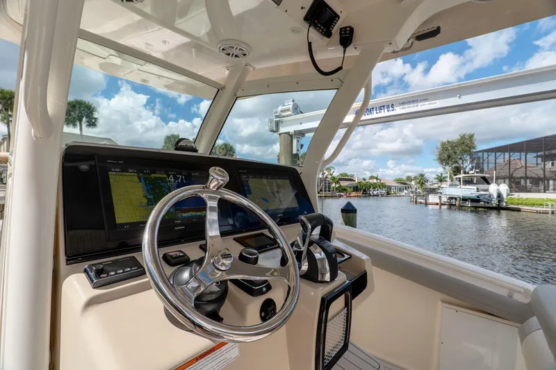 Slide: The Image of 2019 Scout 320 LXF boat helm with steering wheel and navigation screens. - 12
