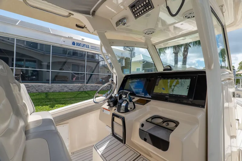 Slide: The Image of Interior view of 2019 Scout 320 LXF boat cockpit with navigation screens. - 14