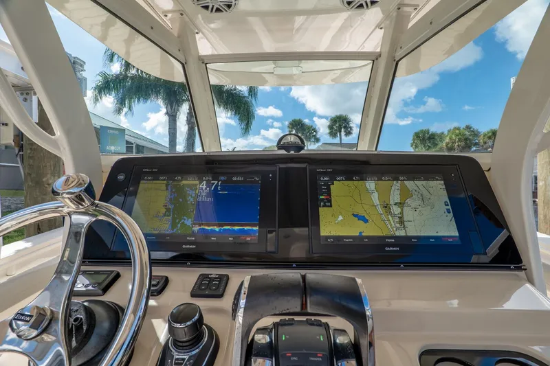 Slide: The Image of 2019 Scout 320 LXF boat dashboard with navigation screens and steering wheel. - 16