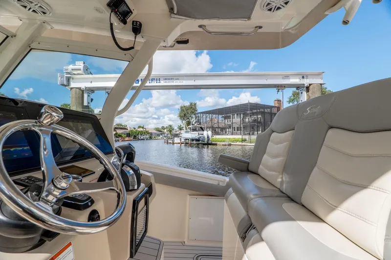 Slide: The Image of Interior view of 2019 Scout 320 LXF boat with steering wheel and seating. - 17