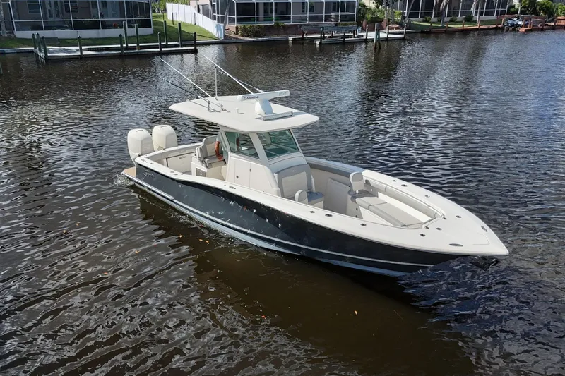Slide: The Image of 2019 Scout 320 LXF boat on calm water, featuring sleek design and dual engines. - 5