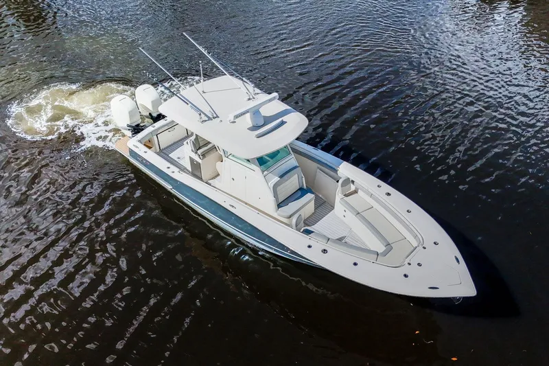 Slide: The Image of 2019 Scout 320 LXF boat cruising on calm water, showcasing sleek design and powerful engines. - 6