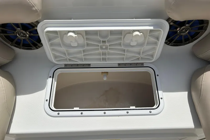 Slide: The Image of Open storage compartment on 2014 NauticStar 203SC Sport Deck boat, surrounded by beige seating. - 13