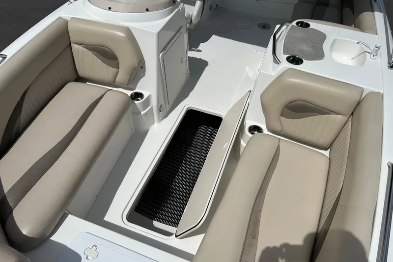 Slide: The Image of 2014 NauticStar 203SC Sport Deck interior with beige seating and storage compartment. - 16