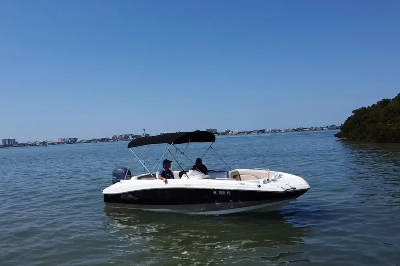 Slide: The Image of 2014 NauticStar 203SC Sport Deck boat on calm water under clear blue sky. - 19