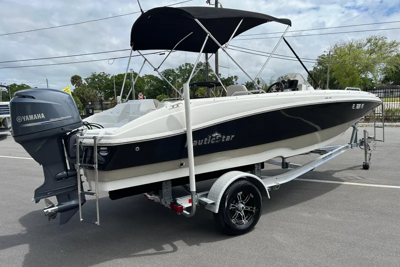 Slide: The Image of 2014 NauticStar 203SC Sport Deck boat on trailer with Yamaha outboard motor. - 2