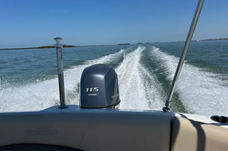 Slide: The Image of 2014 NauticStar 203SC Sport Deck boat cruising on open water with Yamaha 115 engine. - 20