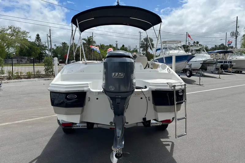 Slide: The Image of 2014 NauticStar 203SC Sport Deck boat with outboard motor, parked on a trailer. - 3