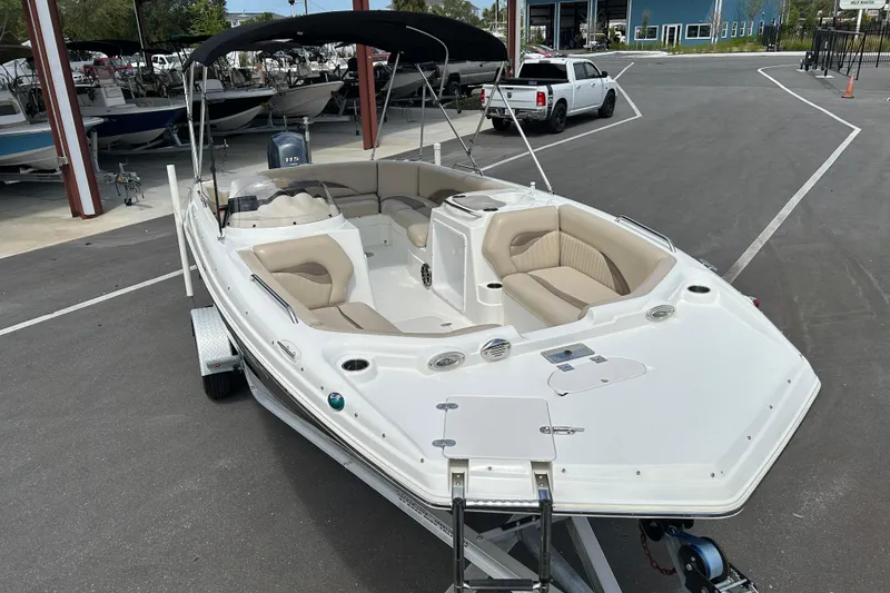 Slide: The Image of 2014 NauticStar 203SC Sport Deck boat with beige seating and black canopy. - 6