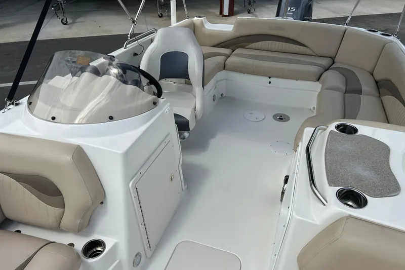Slide: The Image of 2014 NauticStar 203SC Sport Deck boat interior with beige seating and steering console. - 9