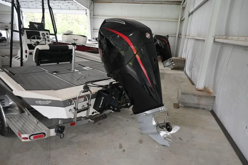 Slide: The Image of 2023 Vexus AVX2180CC boat with powerful outboard motor in a garage setting. - 2