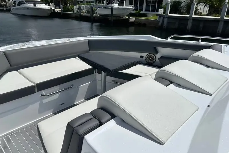 Slide: The Image of 2023 Cruisers Yachts 38 GLS OB interior with sleek seating and table, docked by the water. - 10