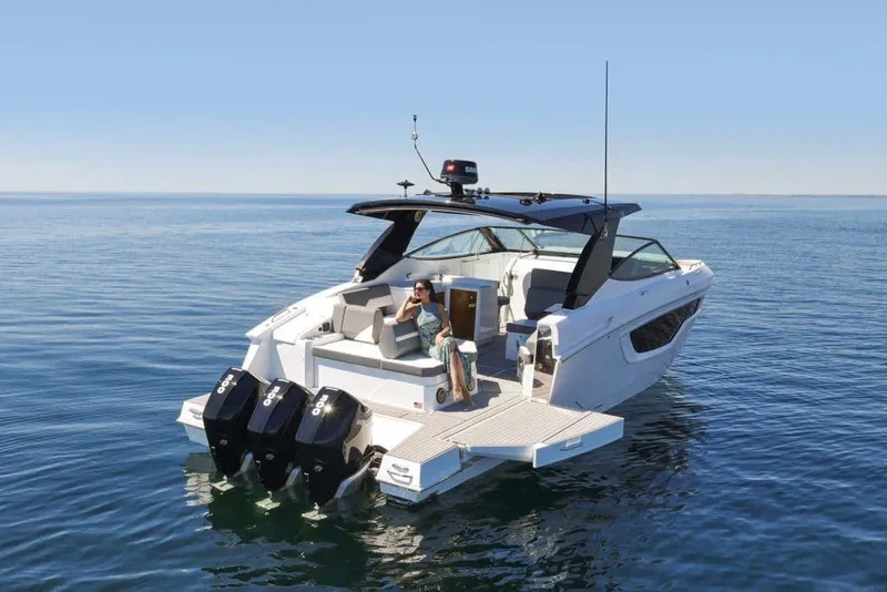 Slide: The Image of 2023 Cruisers Yachts 38 GLS OB on calm water, featuring sleek design and triple outboard engines. - 4