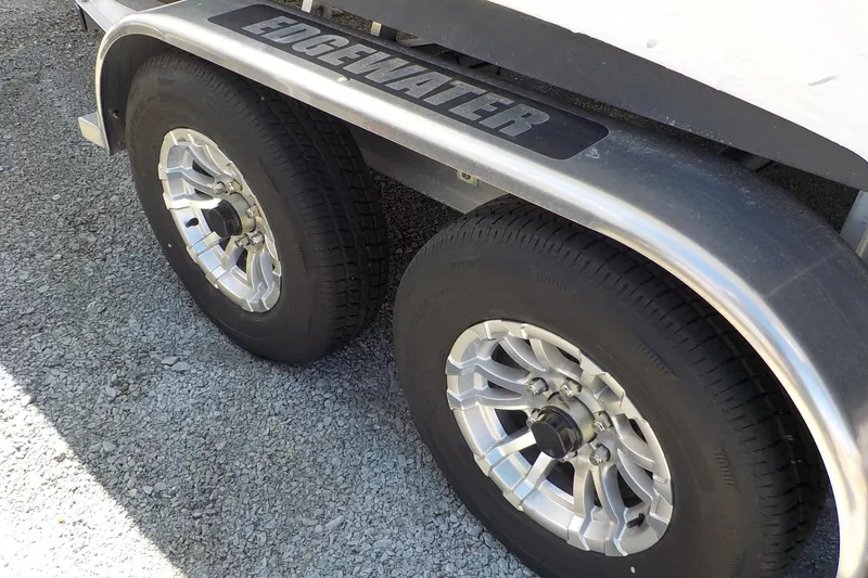 Slide: The Image of Trailer wheels of a 2022 Edgewater 230CC boat on gravel surface. - 10