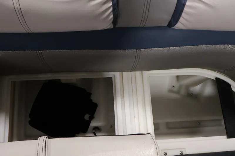 Slide: The Image of Interior storage compartments of a 2018 Sweetwater 2186 boat, featuring cushioned seating. - 13