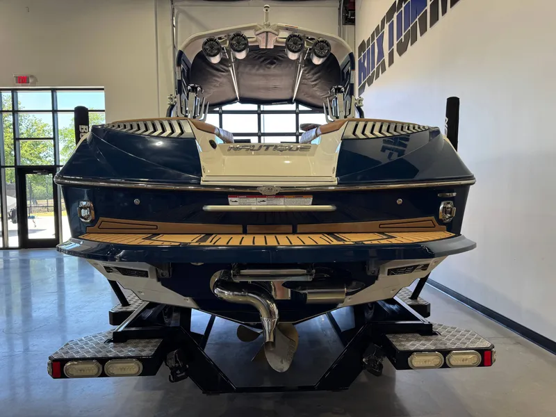 Slide: The Image of Rear view of a 2019 Nautique Super Air Nautique G25 boat in showroom. - 6