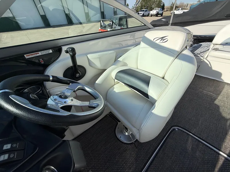 Slide: The Image of Interior of a 2012 Monterey 264FS boat with steering wheel and seat. - 18