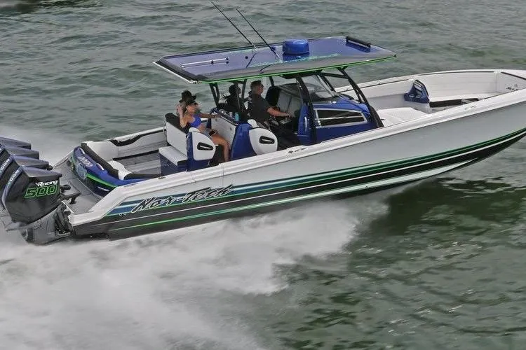 Slide: The Image of 2024 Nor-Tech 390 Sport Center Console boat cruising on water with passengers. - 2