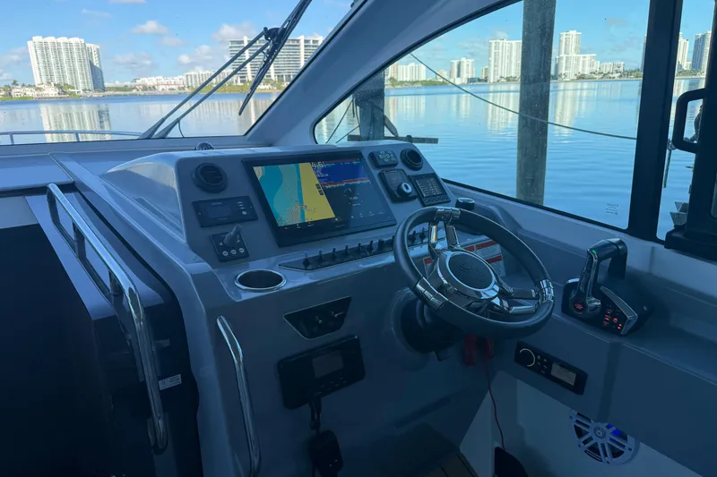 Slide: The Image of Cockpit of 2023 Beneteau Gran Turismo 32 with modern navigation system and waterfront view. - 10