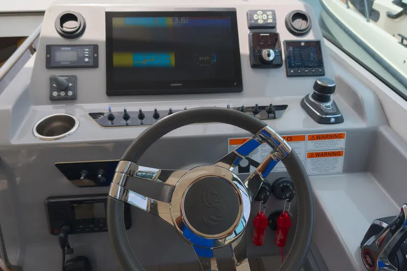 Slide: The Image of 2023 Beneteau Gran Turismo 32 dashboard with steering wheel, controls, and navigation display. - 19