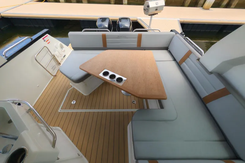 Slide: The Image of 2023 Beneteau Gran Turismo 32 yacht interior with sleek seating and wooden table. - 20
