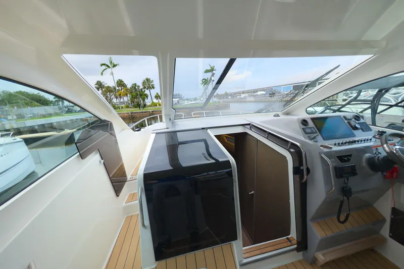 Slide: The Image of 2023 Beneteau Gran Turismo 32 cockpit with modern controls and waterfront view. - 24