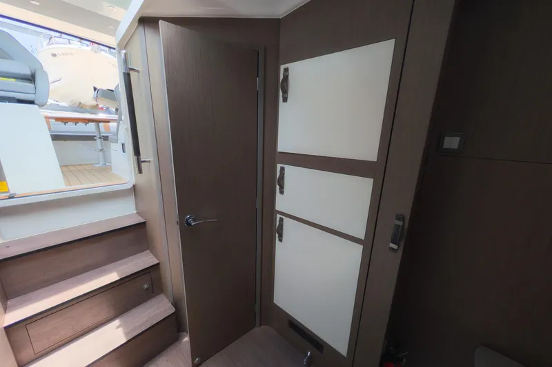 Slide: The Image of Interior view of 2023 Beneteau Gran Turismo 32 yacht, featuring wooden stairs and modern cabinetry. - 31