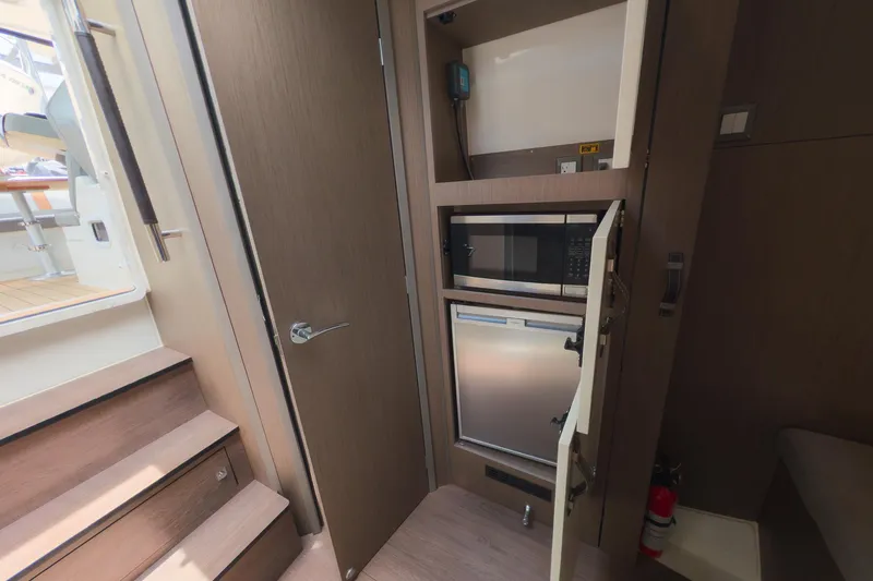 Slide: The Image of Interior of 2023 Beneteau Gran Turismo 32 yacht with microwave and mini-fridge. - 32