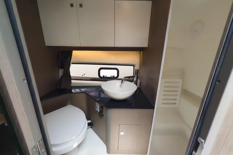 Slide: The Image of 2023 Beneteau Gran Turismo 32 bathroom with modern sink, toilet, and storage cabinets. - 40